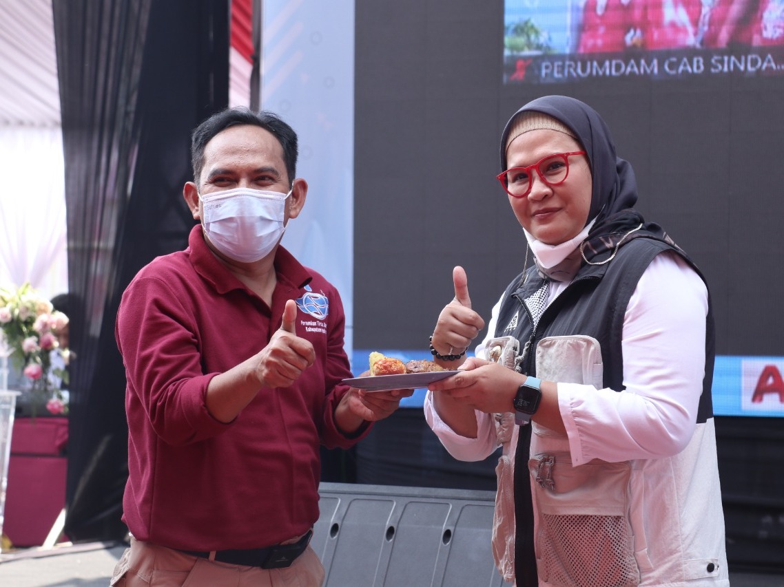 Bupati Indramayu Hj Nina Agustina Saat meyerahkan potongan tumpeng nasi kuning kepada Direktur Perumdam Tirta Darma Ayu Ady Setiawan,pada saat launching DEBAS dan syukuran ulang tahun ke dua Perumdam Tirta Darma Ayu kabupaten Indramayu